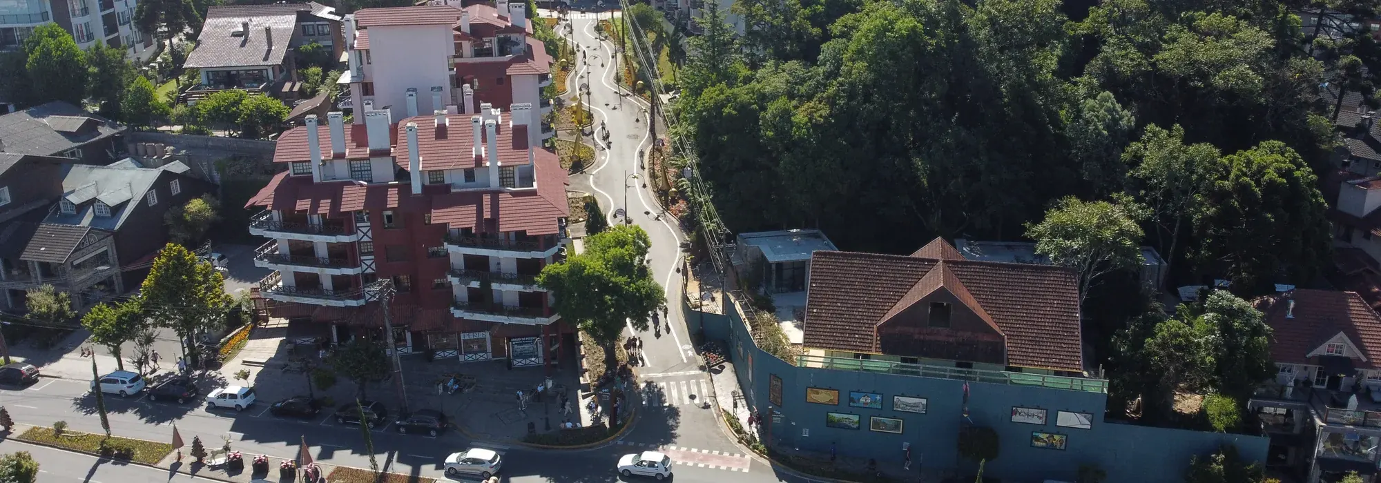 Vista aérea do centro de Gramado, com a rua Coberta, prédios de telhado vermelho e o bosque ao lado
